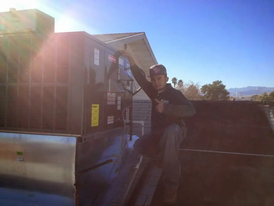 HVAC technician performing AC Tune-Up on a rooftop unit in SeaTac